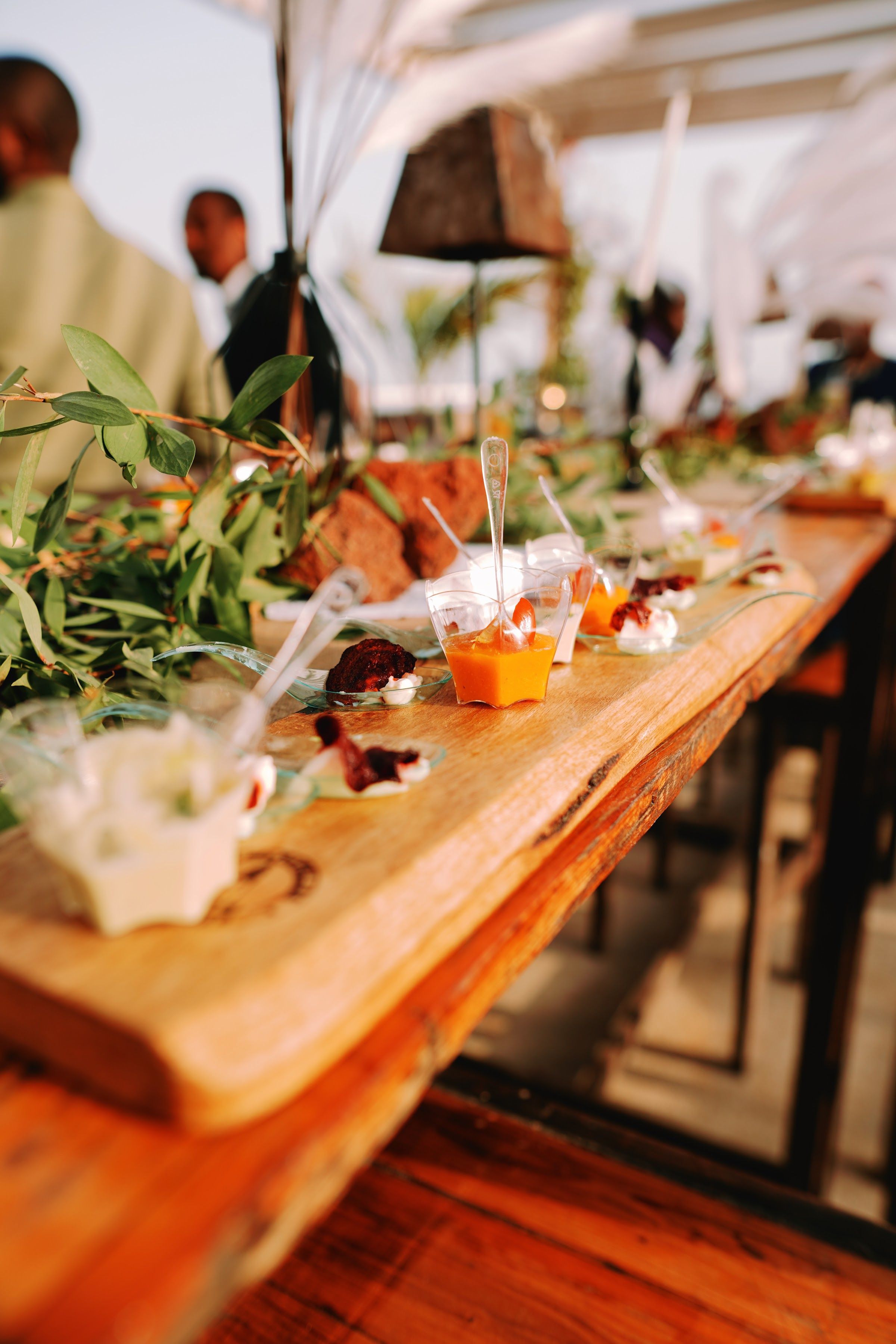 A long wooden table of canapés at an outdoor event