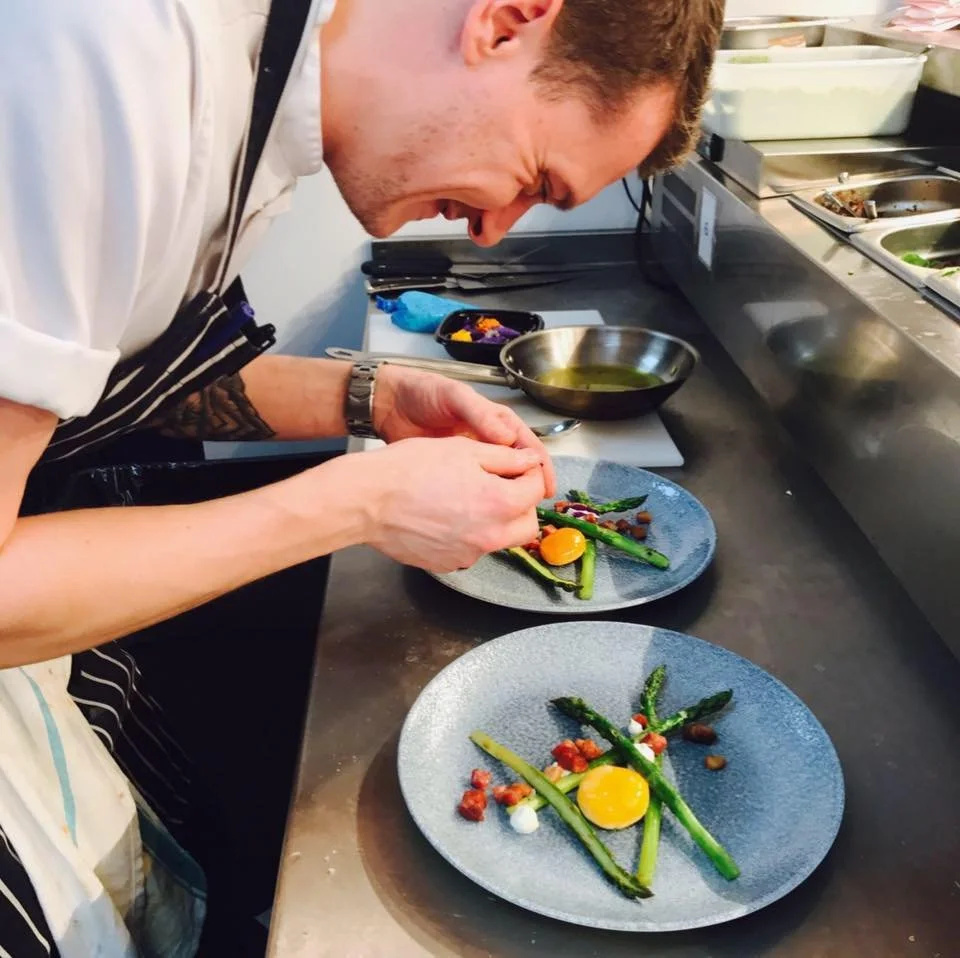 Peter Godwin plating a dish of asparagus at the pass